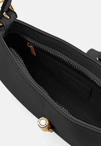 Borsa nera con materiale liscia, chiusura con zip e dettagli in oro. L'interno include una tasca con zip e una foderatura a contrasto.