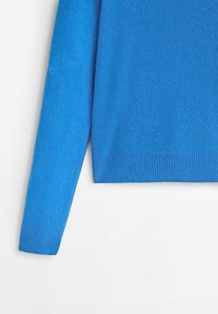 Maglione azzurro lavorato a maglia con colletto rotondo, maniche lunghe e polsini a costine. Il tessuto appare morbido con una superficie liscia.