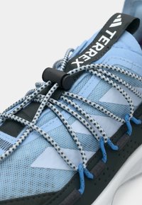 Μπλε αθλητικό παπούτσι με επάνω μέρος από δίχτυ, ανακλαστικές λεπτομέρειες, ελαστικά κορδόνια και στιβαρή μαύρη σόλα με αντίθετες χρωματικές λεπτομέρειες.