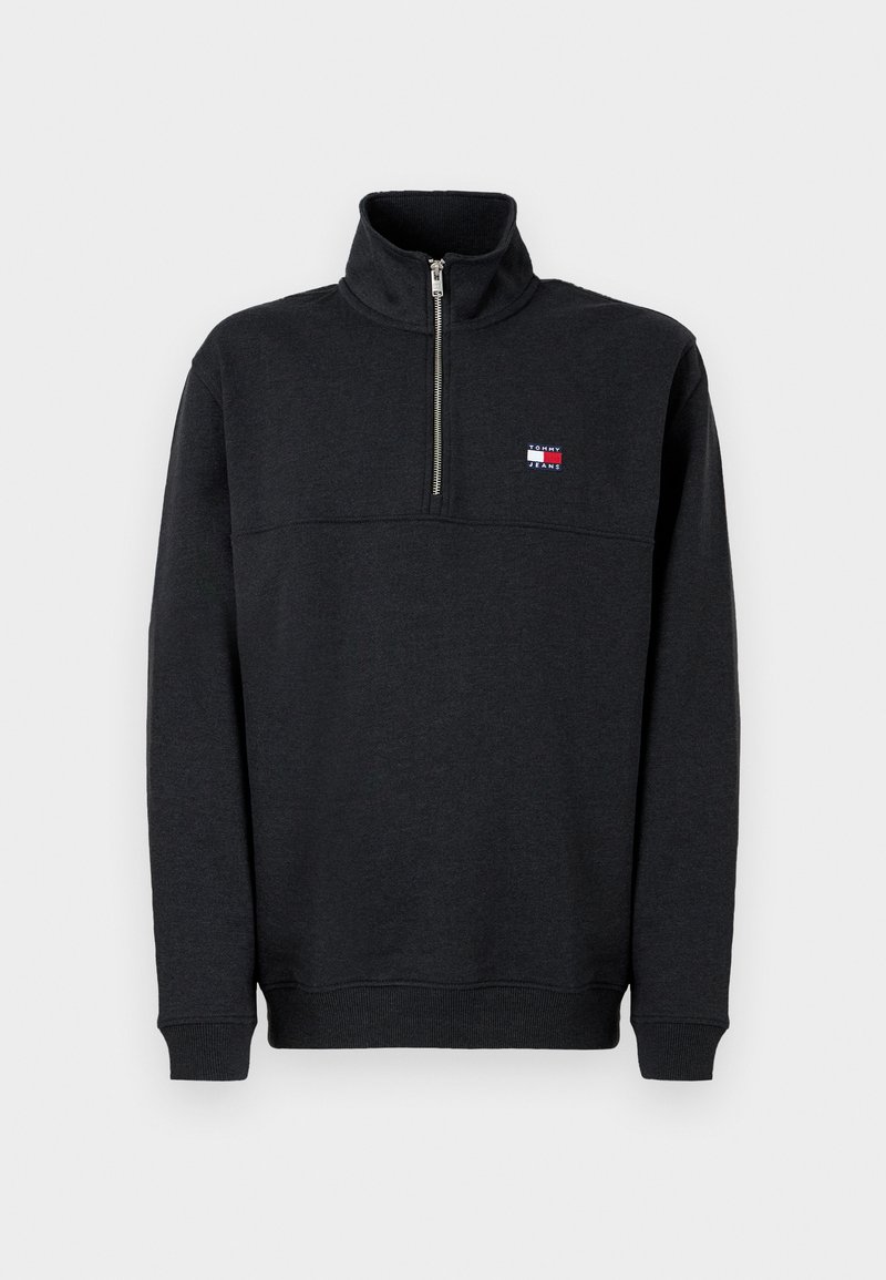 Schwarzer Pullover mit Viertelreißverschluss und hohem Kragen, gerippten Bündchen und Saum sowie einem kleinen rechteckigen Tommy Jeans Logo auf der linken Brust.