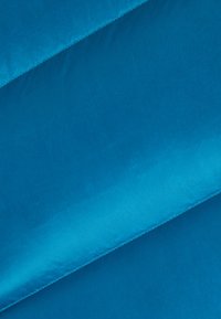 Tissu turquoise vif présentant une texture lisse avec des variations subtiles de brillance. Deux panneaux se chevauchant, mettant en valeur des bords et des coutures nets.