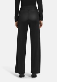 Zwarte wijde pantalon, gemaakt van zachte stof met een gladde tekstuur, voorzien van een hoge tailleband en een vloerlange pasvorm.