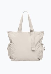Sac fourre-tout beige avec un design texturé et rembourré. Dispose de doubles poignées supérieures et de sangles latérales ajustables pour un rangement extensible.