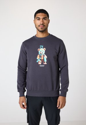 Dark gray sweatshirt with ribbed cuffs and hem, featuring a colorful graphic of a bear with a crown on the chest.