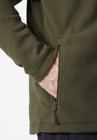 Giacca in fleece verde oliva con tasca laterale con zip, caratterizzata da una consistenza morbida e maniche a polsino. Design semplice senza ulteriori motivi.