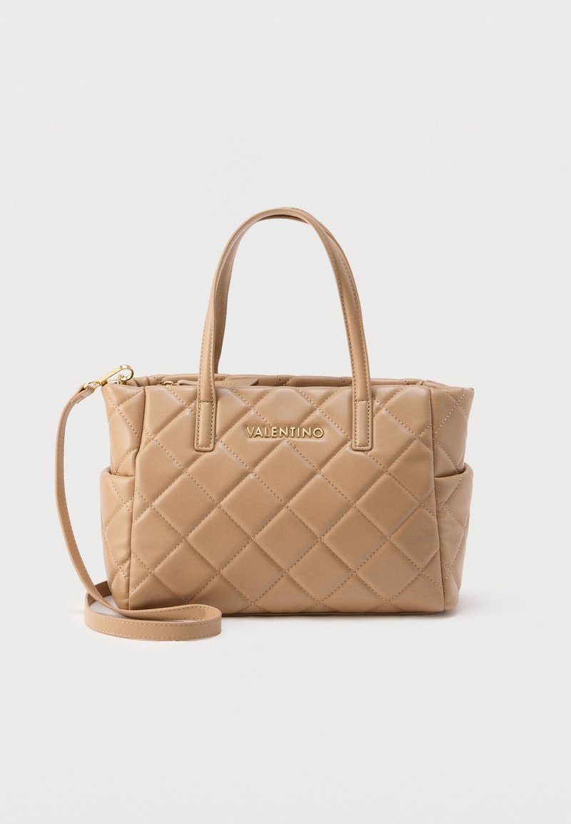 Μπεζ τσάντα χειρός Valentino με καπιτονέ υφή, διπλές επάνω λαβές, πλαϊνές τσέπες και αφαιρούμενο ιμάντα ώμου, σε απλό φόντο.