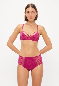 Fuchsia beha van doorzichtig materiaal, met golvende randen en luipaardprint, gecombineerd met bijpassende hoog-waist slipjes met een vergelijkbaar patroon.