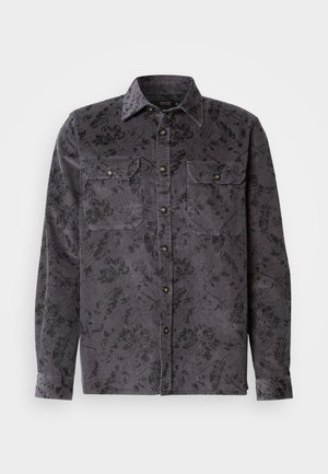 Camicia in corduroy grigio con motivo floreale nero, due tasche sul petto, colletto a punta e bottoni metallici. Tessuto testurizzato con righe verticali.