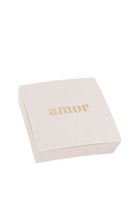 Caja cuadrada de color rosa suave con una superficie lisa y el texto "amor" en dorado en la parte superior. Los bordes son ligeramente redondeados, lo que le da un aspecto moderno.