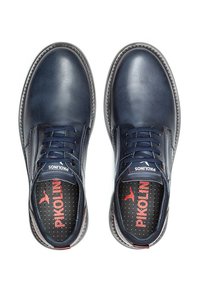 Zapatos de cuero azul marino con punteras redondas, diseño tradicional de cordones, costuras en contraste y plantillas perforadas con el logo de "Pikolinos".