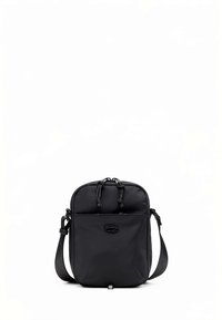 Mala tiracolo de nylon preta com forma arredondada, fecho de cordão, alça ajustável e um pequeno emblema com marca na frente.