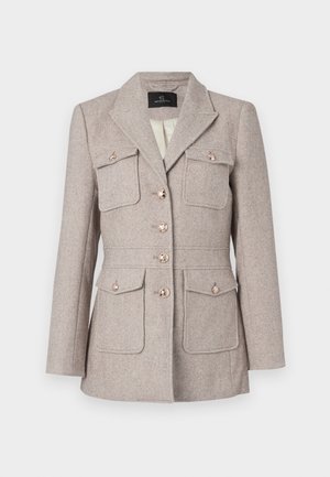 Sakó s houndstooth vzorom v svetlej béžovej farbe, s presne strihaným strihom, obsahujúce dve náprsné vrecká, zapínanie na gombíky a gombíky v striebornej farbe.