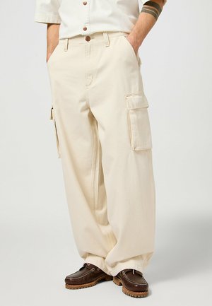 Beige cargobroeken met een relaxed fit, dubbele zijzakken en een stevige canvas stof met een zachte textuur.