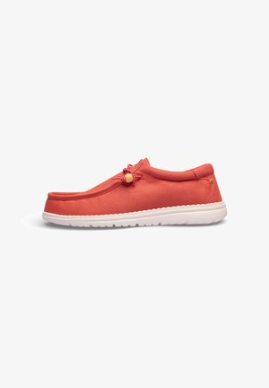 Zapato casual rojo sin cordones con suela blanca y cordón elástico con un tándem de madera, mostrado en perfil lateral sobre fondo blanco.