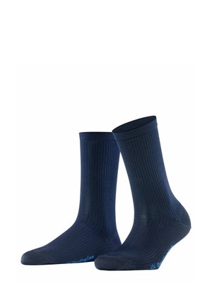 Para ciemnoniebieskich skarpetek typu crew z prążkowaną strukturą, stojących pionowo, z małym niebieskim napisem brandingowym w okolicy palców na białym tle.