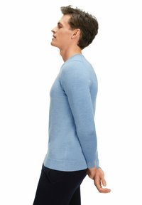 Himmelblaues, langärmliges Sweatshirt mit Rundhalsausschnitt. Aus glattem, weichem Material gefertigt. Mit gerippten Bündchen und Saum, maßgeschneiderter Passform.