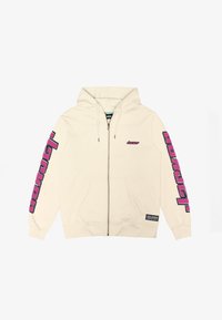 Krém színű, cipzáras kapucnis pulóver, állítható húzózsinórral. Az ujjakon és a mellkason rózsaszín hímezett feliratok találhatók. Elöl zsebekkel rendelkezik.