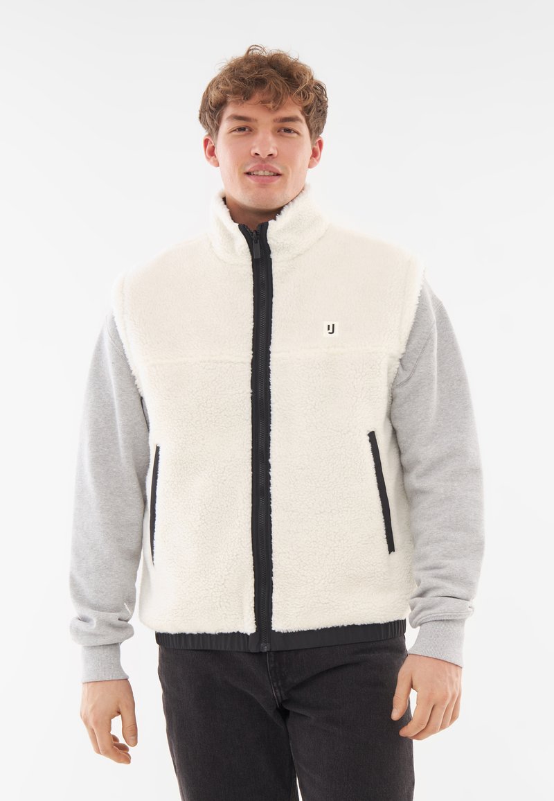 Fleeceväst i grädde med hög krage, full zip och grå ärmar. Har sidofickor och en liten logotyp på bröstet.