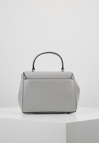 Szara skórzana torebka o uporządkowanym kształcie, z górnym uchwytem i czarnymi akcentami. Charakteryzuje się gładką teksturą oraz subtelnymi detalami przeszyć.