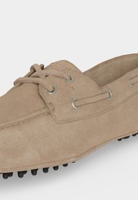 Hellbrauner Wildleder-Fahrerschuh mit Schnürdetail, perforierter Gummisohle mit Grip und Metallösen.