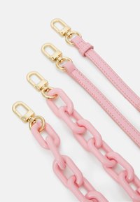 Čtyři růžové pásky: dva hladké kožené s pozlacenou kovovou výbavou, jeden plochý a jeden připevněný ve stylu řetězových ok z lesklých, silných článků.