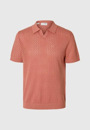 Polo a maniche corte di colore corallo con un motivo a rombi testurizzato, scollatura a V e polsini e orlo a coste. Realizzato in un materiale knit leggero.