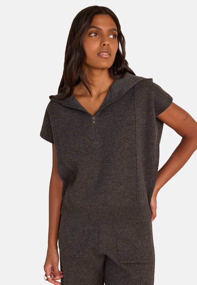 Dark gray short-sleeve hoodie with a half zipper, featuring a relaxed fit and textured fabric. Includes side pockets and a hood.