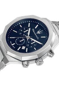 Silverfärgad klocka i rostfritt stål med en oktagonal boett, blå texturerad urtavla, silverfärgade visare, två sub-diskar och datumvisning kl. 6.