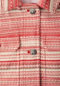 Tissu à col rouge et blanc à motifs géométriques, avec deux boutons métalliques gravés "Street One" et rabats de poche.