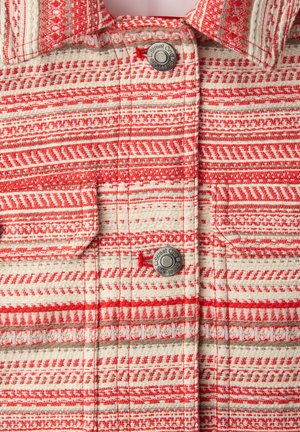 Tissu à col rouge et blanc à motifs géométriques, avec deux boutons métalliques gravés "Street One" et rabats de poche.