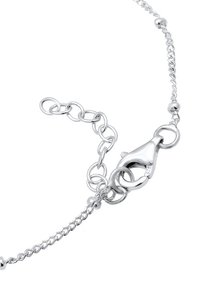 Silverfärgad kedjearmband med en kräftklämma, sammanlänkade länkar och små runda pärlor som accenter, med en slät och polerad finish.