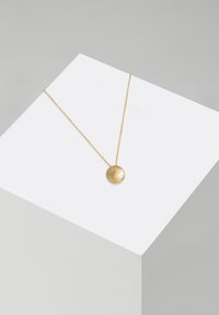 Guld pendant halskæde med en cirkulær, tekstureret charme med en lille, rund accent. Hængende på en delikat kæde.