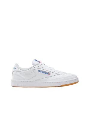 Witte lage Reebok sneaker met blauw logo, Union Jack vlagdetails, witte veters en gum rubberen zool op een effen witte achtergrond.