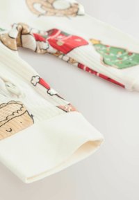 Bawełniana piżama dziecięca z festywnym nadrukiem słodkości i dekoracji, z białym ściągaczem i miękką fakturą.