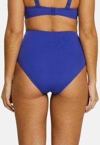 Bas de bikini taille haute en tissu bleu uni, avec une texture lisse, des coutures minimales et un ajustement confortable.