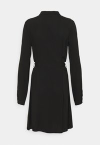 Robe noire à manches longues avec une taille cintrée et un col, vue de dos sur fond blanc uni.