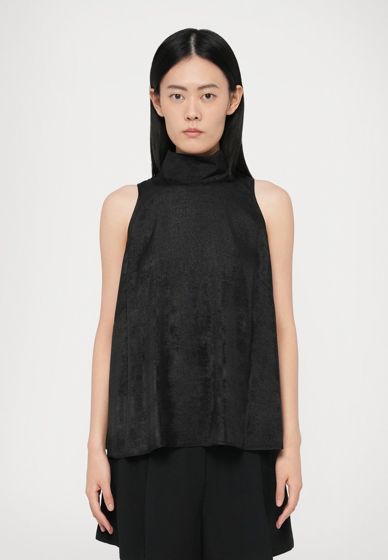Zwarte mouwloze top met een hoge kraag, gemaakt van zachte, gestructureerde stof. Het ontwerp heeft een losse silhouet en een minimalistische stijl.