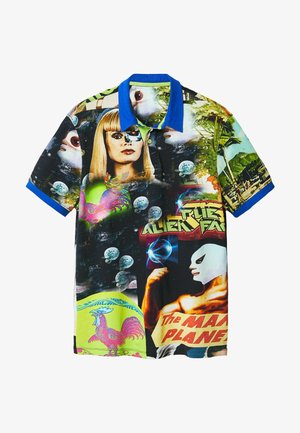 Polo avec col et manches bleus présentant un collage d'une femme blonde, d'un lutteur masqué, de coqs et d'éléments de l'espace.