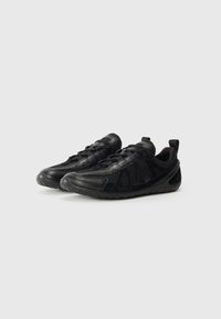 Scarpe da ginnastica nere realizzate con un mix di materiali sintetici texturizzati e lisci, con un design a lacci e una robusta suola in gomma.