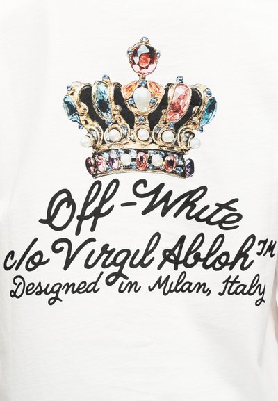 Λευκό μπλουζάκι με γραφικό ενός κοσμημένου στέμματος με χρυσά, ροζ, μπλε και διαφανή πετράδια, με μαύρο κείμενο που γράφει "Off-White c/o Virgil Abloh."