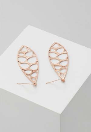Náušnice z růžového zlata s průřezovým designem listu, umístěné na bílém geometrickém podstavci na šedém pozadí.
