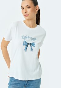 Weißes Baumwoll-T-Shirt mit einem blauen Schleifen-Design und dem Text "Das Leben ist ein Geschenk" in einer verspielten Schriftart. Mit kurzen Ärmeln und lockerer Passform.