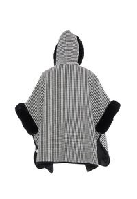 Schwarz-weißer Hahnentritt-Poncho mit Kapuze, versehen mit schwarzen Kunstpelz-Akzenten an den Rändern und strukturiertem Stoff.