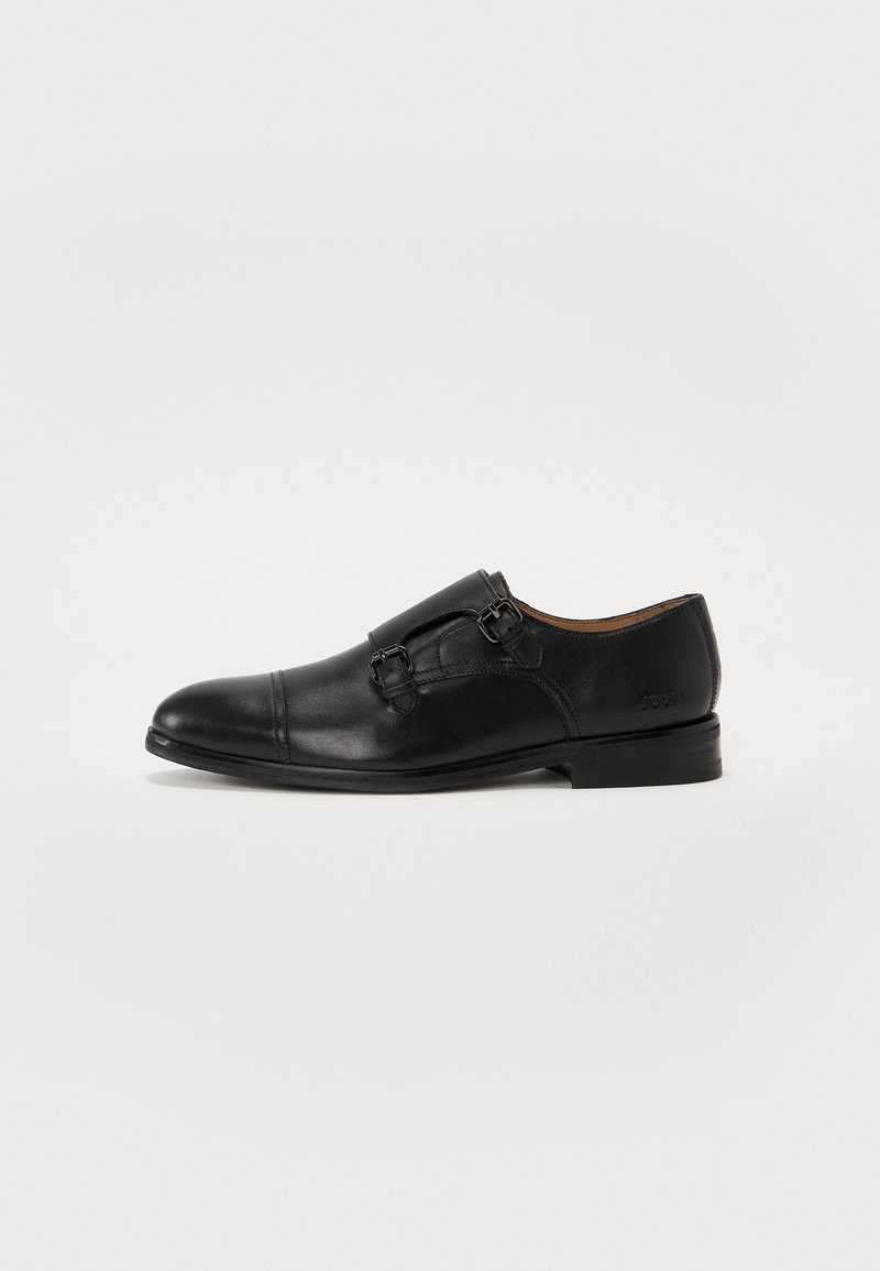 Black leather dress shoe with a rounded toe, double buckle design, and a low heel. Features smooth texture and subtle stitching details.