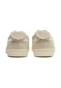 Beige Wildlederschuhe mit strukturierten Gummisohlen, mit einem runden Akzent auf der Rückseite. Einfaches Design mit zwei horizontalen Streifen.