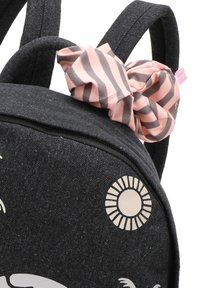 Zaino in tessuto nero con un accessorio a scrunchie a righe rosa, design circolare del sole e chiusura con zip. Texture morbida, forma compatta.