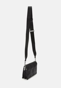 Borsa a tracolla nera con motivo testurizzato, accessori in argento e tracolla regolabile. Realizzata in un materiale liscio con chiusura a zip.