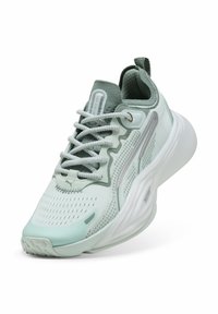 Zapatilla deportiva verde claro con parte superior de malla y cordones, que cuenta con una suela blanca acolchada, detalles reflectantes y acentos de superficie texturizada.