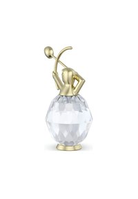 Bottiglia di profumo in cristallo con forma geometrica, facce trasparenti e una figura dorata che tiene un bastone stilizzato, con un accento metallico lucido.