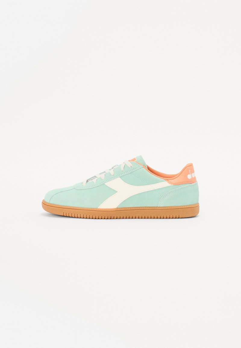 Mint green suede sneakers with white accents, featuring a rubber sole and orange interior. Lace-up design with a logo on the heel.
